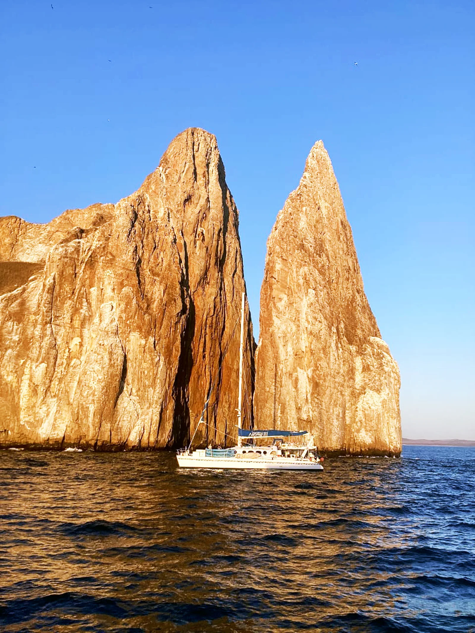 Nemo III catamaran sailing in front of Kicker Rock in Galapagos
