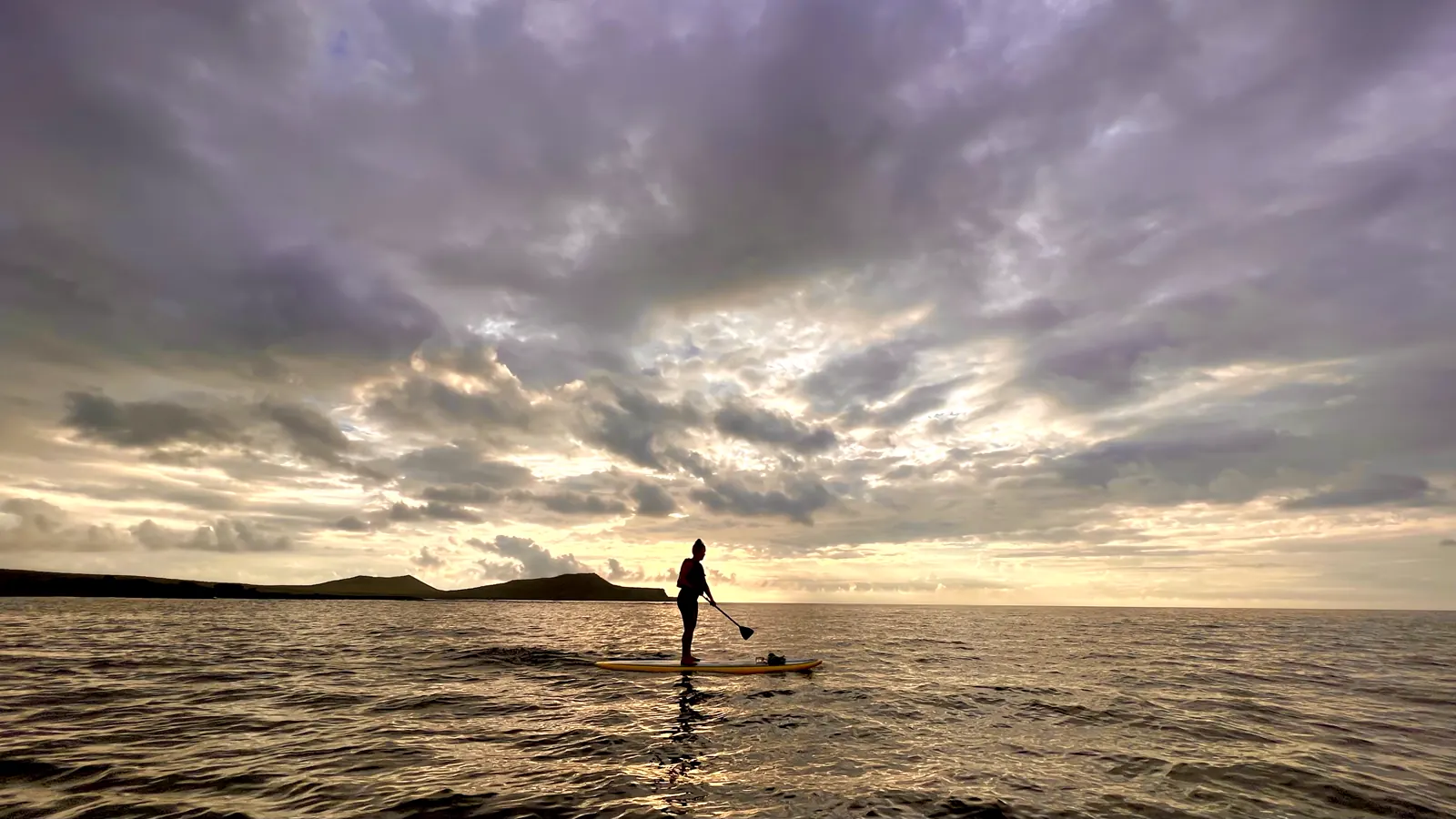 Paddleboarding at sunset in the Galapagos sea