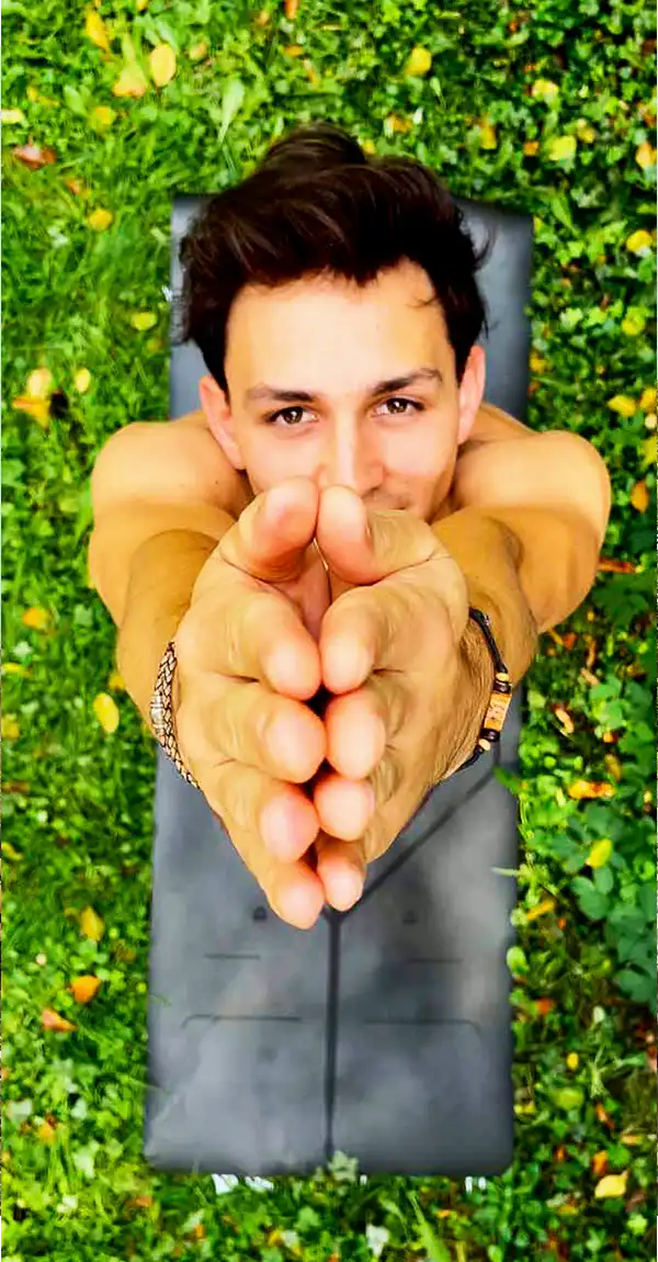 Jan practicing yoga outdoors on a grassy field