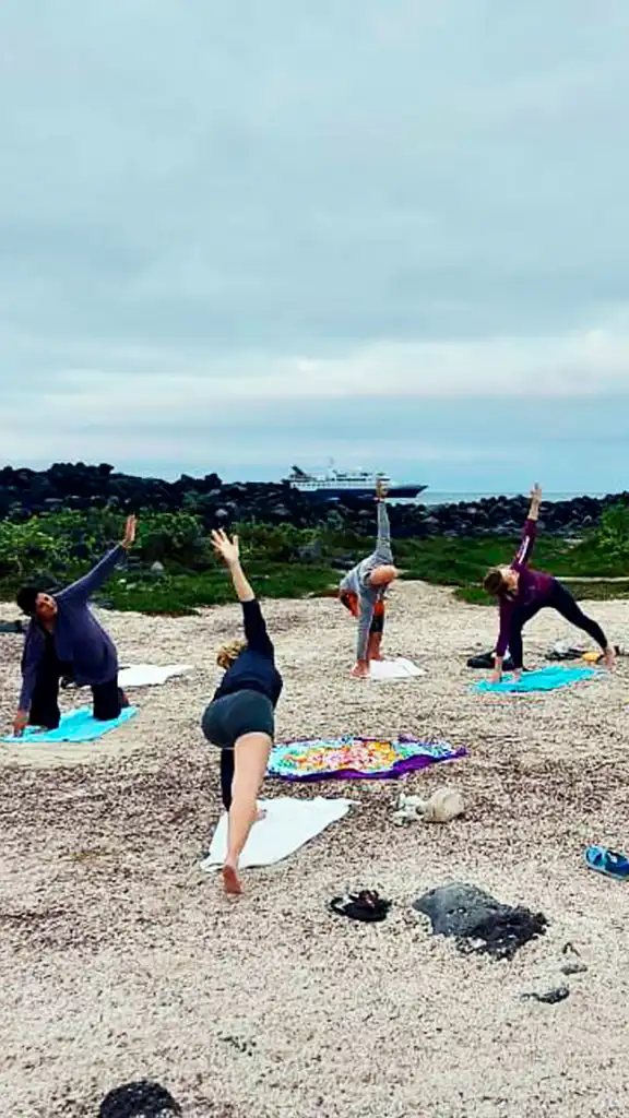 Beach yoga session during Carolina’s Galápagos retreat Carolina leading a beach yoga session with a group in the Galápagos Islands